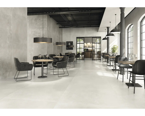 Geräumiges Restaurant mit Tischen, Stühlen und Bodenfliesen.