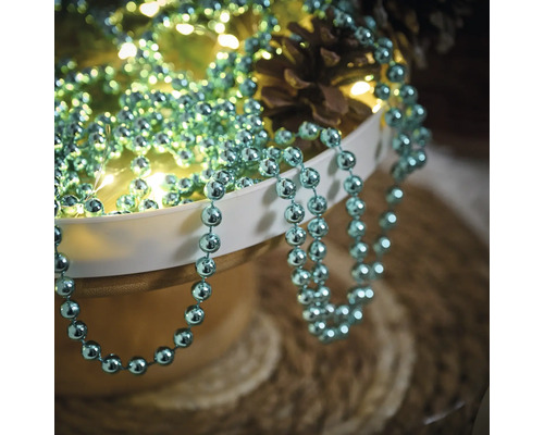 Arrangement décoratif avec guirlande de perles, guirlande lumineuse et pommes de pin
