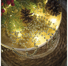 Décoration avec des branches de sapin, des pommes de pin et une guirlande de boules dorées
