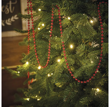 Sapin de Noël décoré avec une guirlande de perles rouges et des illuminations