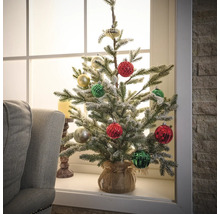 Sapin de Noël artificiel décoré sur un rebord de fenêtre