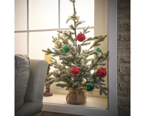 Sapin de Noël artificiel décoré sur un rebord de fenêtre