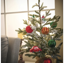 Dekorierter Weihnachtsbaum mit Christbaumkugeln und Autoschmuck vor einem Fenster