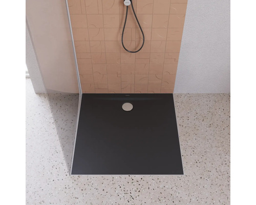 Receveur de douche dans une salle de bains avec pommeau de douche et carrelage