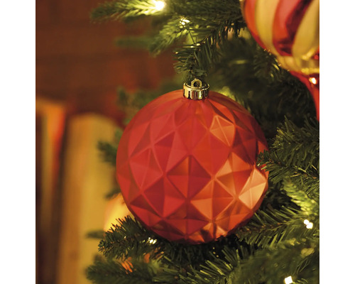 Gros plan d''une décoration de sapin de Noël rouge à facettes sur un sapin de Noël