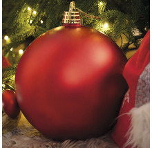 Grande boule de Noël rouge sous un sapin de Noël