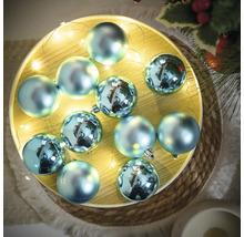 Dekorative blaue Christbaumkugeln auf einem Tablett mit Lichterkette
