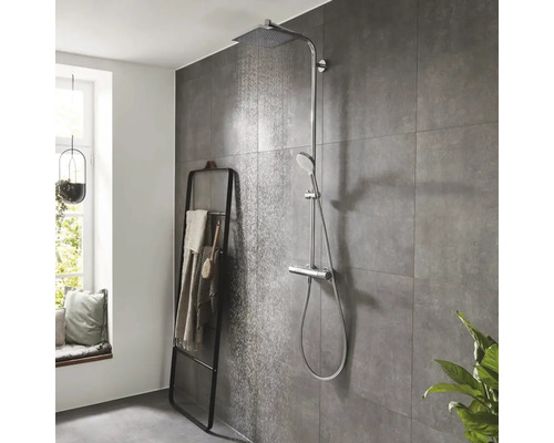 Salle de bains avec robinetterie de douche avec douche de tête et douchette à main et porte-serviettes