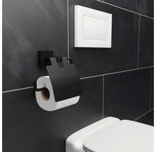 Porte-papier toilette noir avec rouleau de papier toilette sur un mur de salle de bains