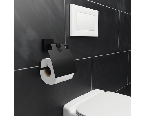 Porte-papier toilette noir avec rouleau de papier toilette sur un mur de salle de bains