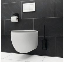 Wandhängendes WC mit Toilettenbürste, Spülkasten und Toilettenpapierhalter in einem Badezimmer