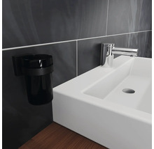 Waschbecken mit Armatur und Zahnputzbecherhalter im Badezimmer