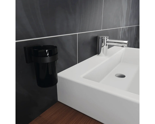 Waschbecken mit Armatur und Zahnputzbecherhalter im Badezimmer