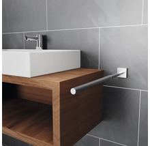 Waschbecken mit Holzunterschrank und Handtuchhalter im Badezimmer