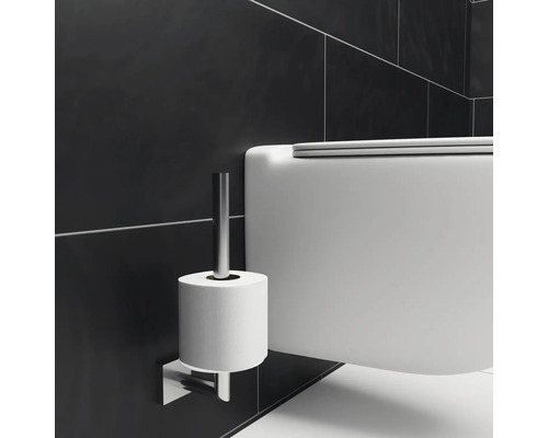 Gros plan de toilettes avec porte-papier toilette mural.