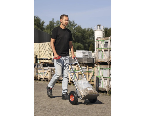 Mann transportiert Sackware mit einer Sackkarre im Aussenbereich