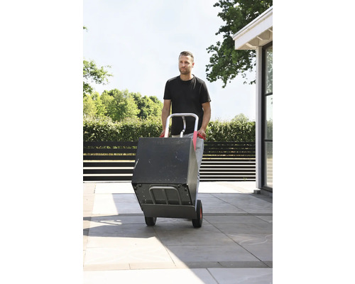 Homme transportant une boîte avec un diable à l''extérieur.