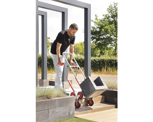 Un homme transporte des bacs à plantes avec un monte-escalier