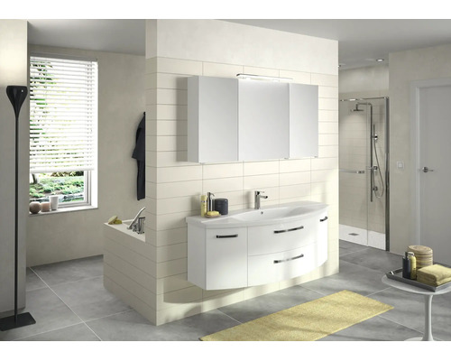 Helles, modernes Badezimmer mit weißem, geschwungenem Waschtischset, Keramikbecken, dreitürigem Spiegelschrank, Glasdusche und grauen Bodenfliesen.