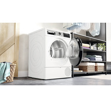 Sèche-linge à pompe à chaleur blanc avec porte ouverte dans une buanderie