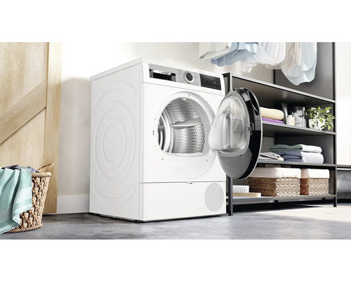 Sèche-linge à pompe à chaleur blanc avec porte ouverte dans une buanderie