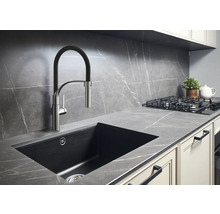 Scène de cuisine avec évier, robinet, plaque de cuisson et plan de travail au design moderne.