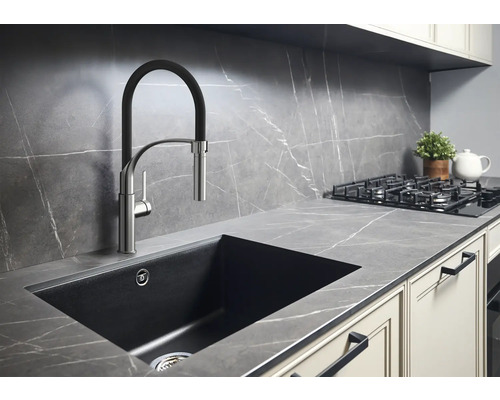 Scène de cuisine avec évier, robinet, plaque de cuisson et plan de travail au design moderne.