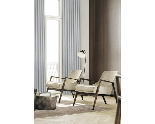 Wohnzimmer mit zwei Sesseln, Stehlampe und Vorhängen vor einem Fenster