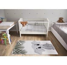 Kinderzimmer mit Kinderbett, Wickeltisch, Bett und Teppich mit Elefantenmotiv.