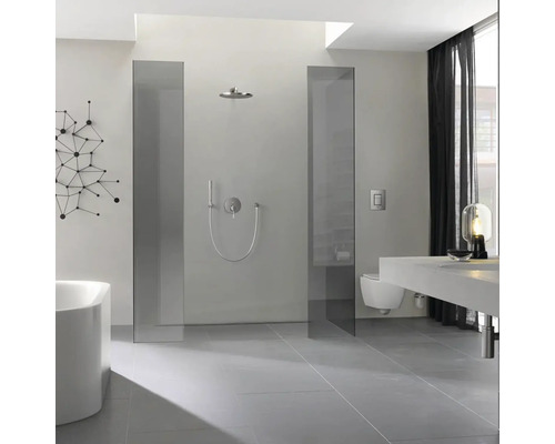 Salle de bains lumineuse avec douche, lavabo et toilettes