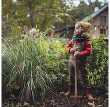 Kind mit Rechen im Garten