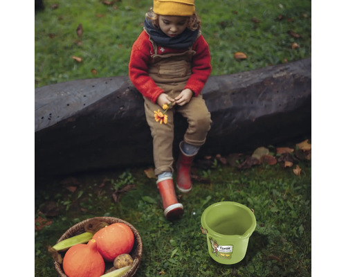 Gartenszene mit Kind, Gemüsekorb und grünem Eimer