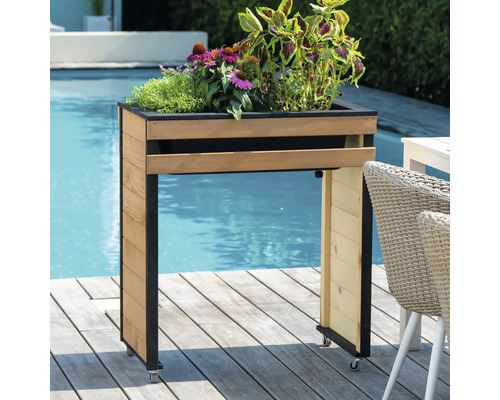 Hochbeet aus Holz mit Rollen und Pflanzen in der Nähe eines Schwimmbeckens.