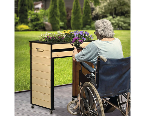 Hochbeet aus Holz mit Rollen für Rollstuhlfahrer im Garten.