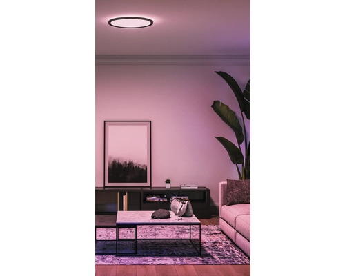 Wohnzimmer mit Deckenleuchte, Couch, Tisch und Dekoration