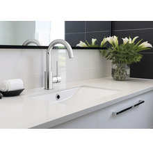 Salle de bain moderne avec lavabo, robinet et éléments décoratifs