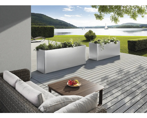 Scène avec deux bacs à plantes rectangulaires plantés sur une terrasse avec vue sur un lac