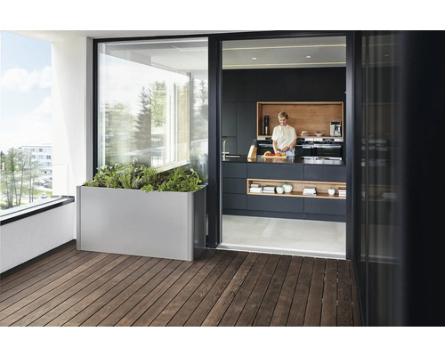 Scène de balcon avec jardinière en métal et femme dans une cuisine moderne