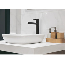 Lavabo avec robinet noir et accessoires de salle de bain sur un meuble-lavabo