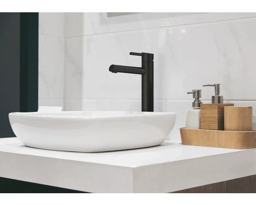Lavabo avec robinet noir et accessoires de salle de bain sur un meuble-lavabo