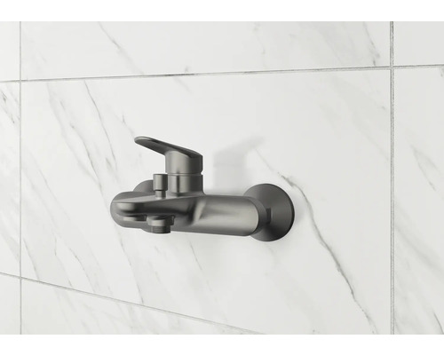 Robinet de douche apparent sur un mur carrelé