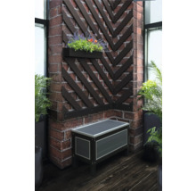 Ecke mit einer Truhe, einem Blumenkasten und dekorativen Holzleisten an einer Backsteinwand