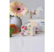 Dekorative Holzpferde mit Blumenmuster neben Blumen in einer Vase als Raumdekoration