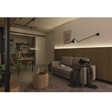 Salon avec canapé, panneaux muraux en bois, lampe et table à manger
