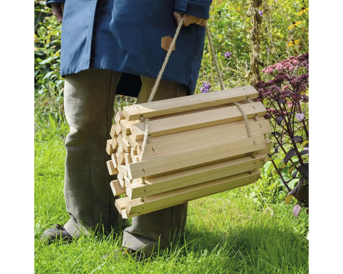 Personne portant un hôtel à insectes en bois avec cordon