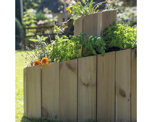 Mehrstufiges Hochbeet aus Holz mit verschiedenen Pflanzen im Garten.