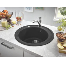 Runde, schwarze Küchenspüle mit Wasserhahn auf einer Küchentheke