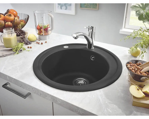 Runde, schwarze Küchenspüle mit Wasserhahn auf einer Küchentheke