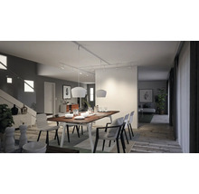 Salle à manger lumineuse avec table à manger, chaises et luminaires de plafond sur un système de rails.