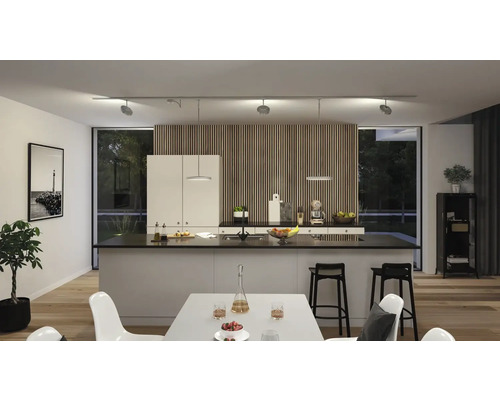 Cuisine moderne avec îlot de cuisson, table à manger et système de rails avec spots